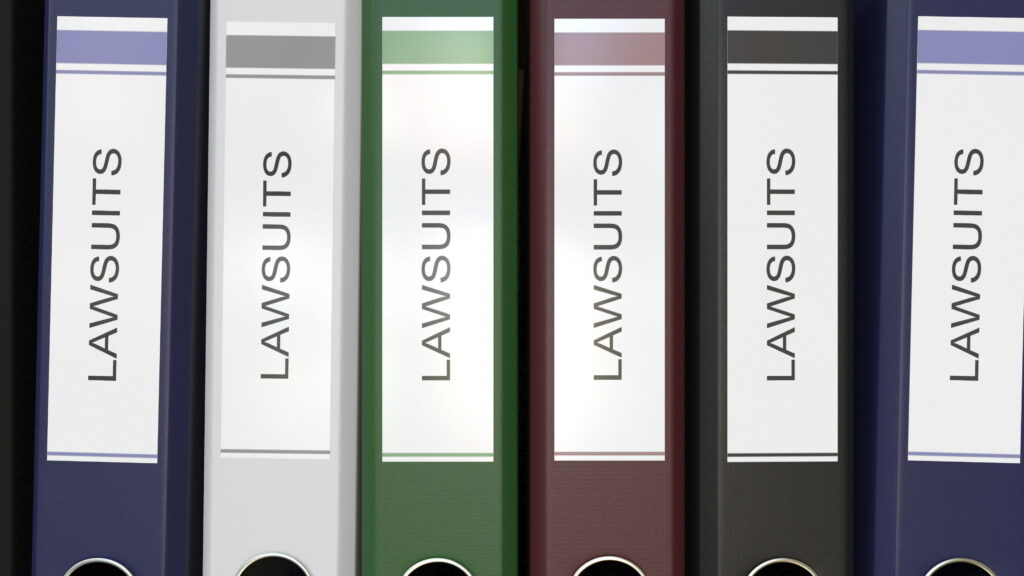 Several big binders showing the word “lawsuits.”