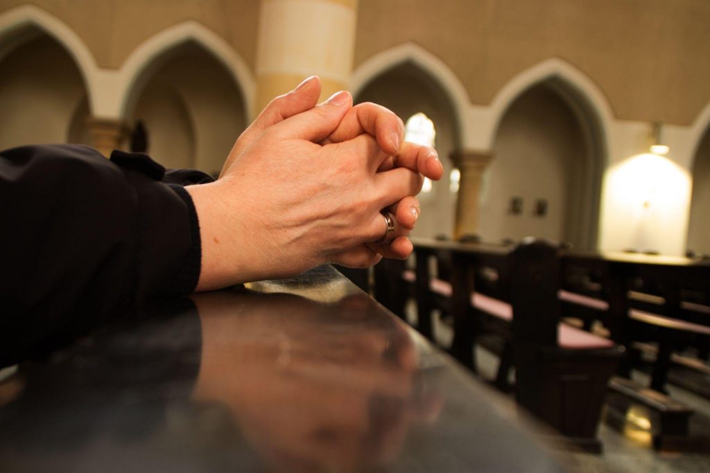 sitting in church with folded hands