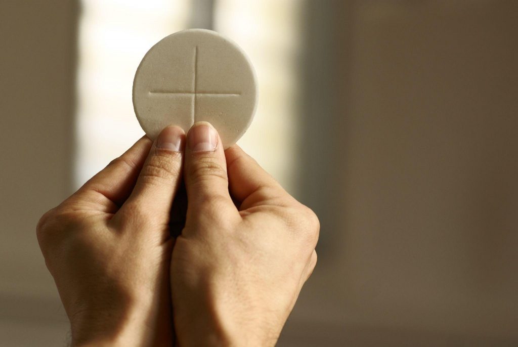 Hands holding communion wafer at church
