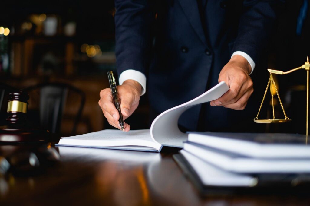 Lawyer writing notes at a desk in his office.