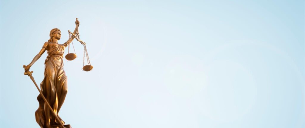 Legal law concept statue of Lady Justice with scales of justice sky background.