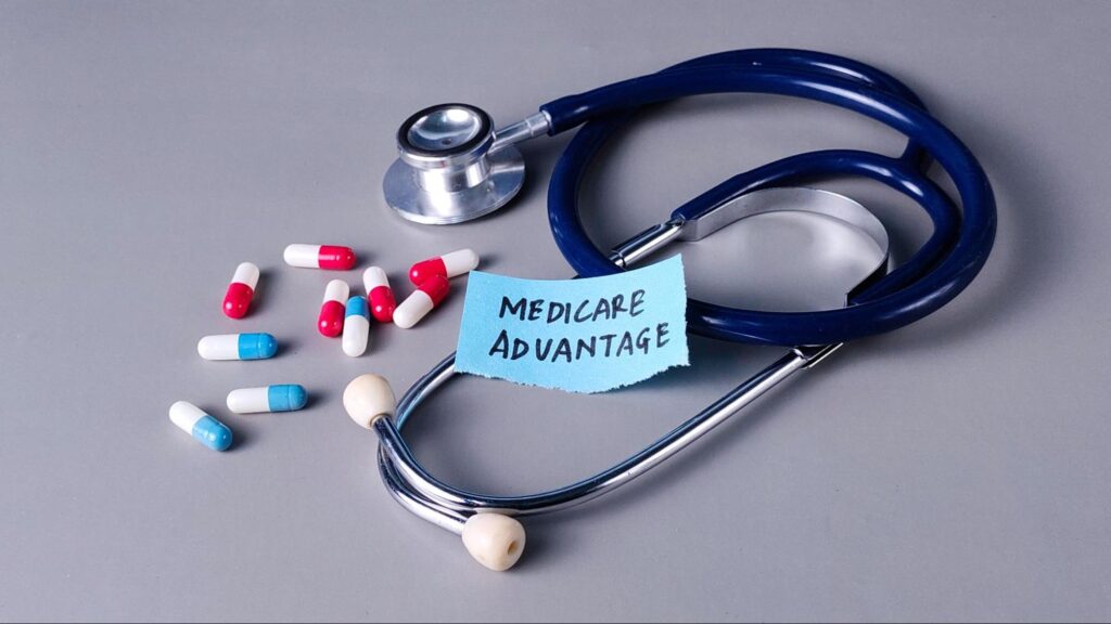 Medicare Advantage Concept with Stethoscope, Note, and Capsules on Gray Background.
