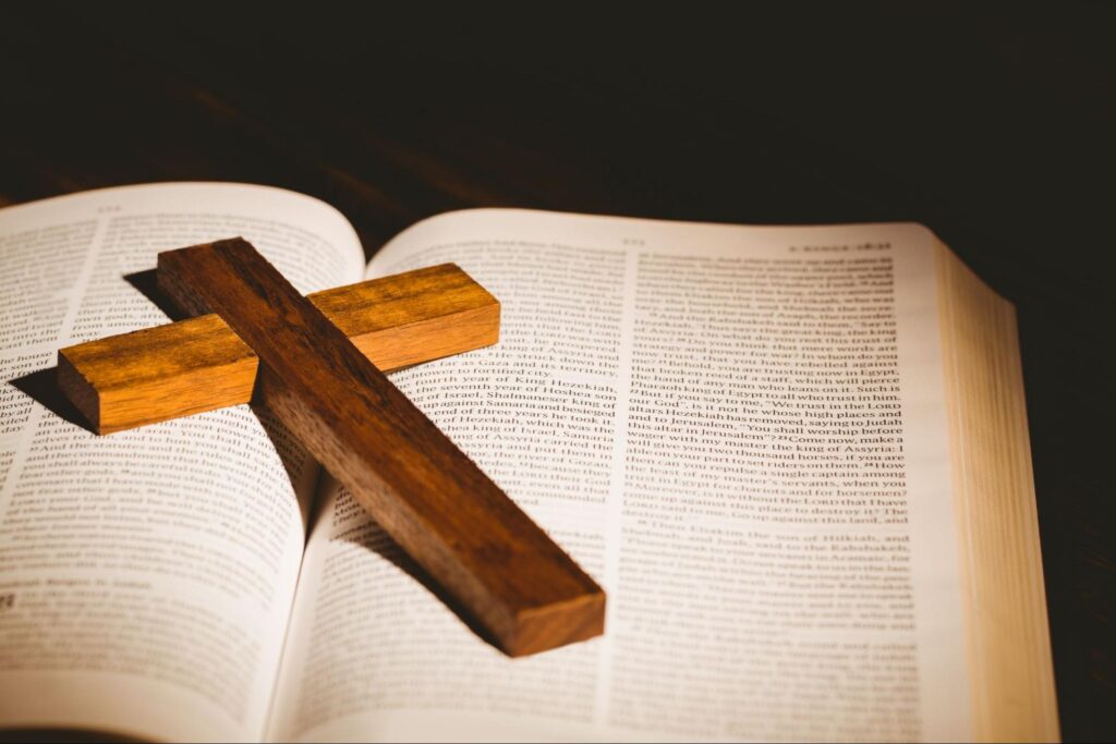 Open bible with crucifix icon.