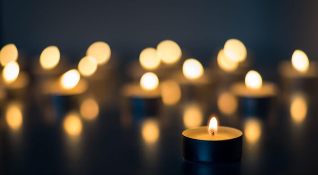 Flame of many candles burning on the background blue color.