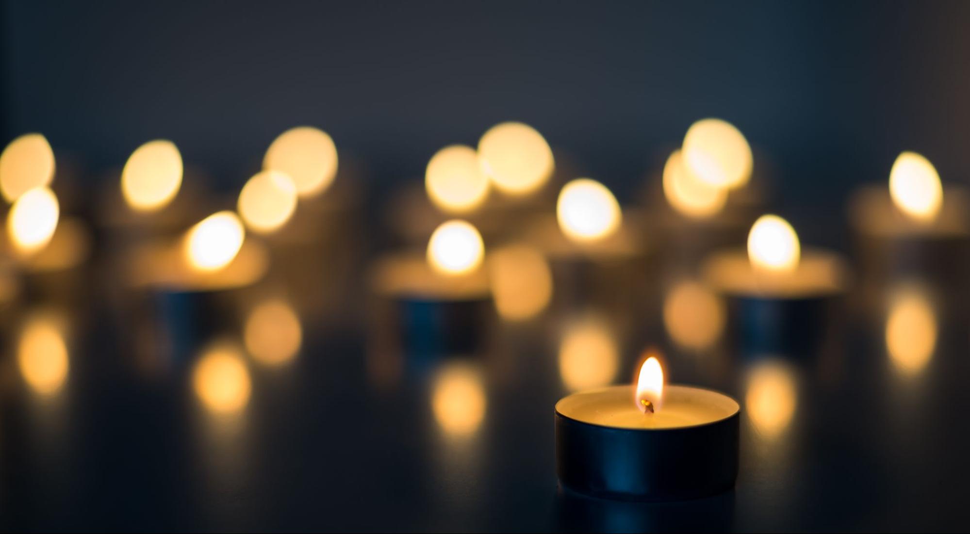 Flame of many candles burning on the background blue color.