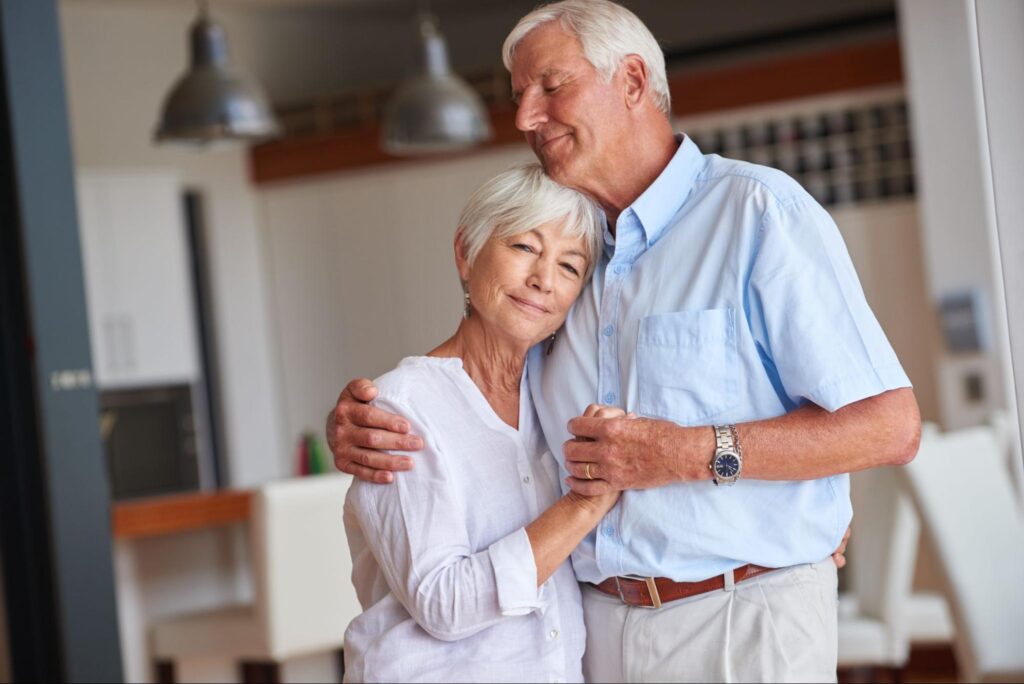Romance, smile or old couple in house with hug, connection or bonding together in retirement.